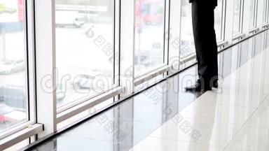 一个人站在最高的位置，凝视着机场候机楼的窗户